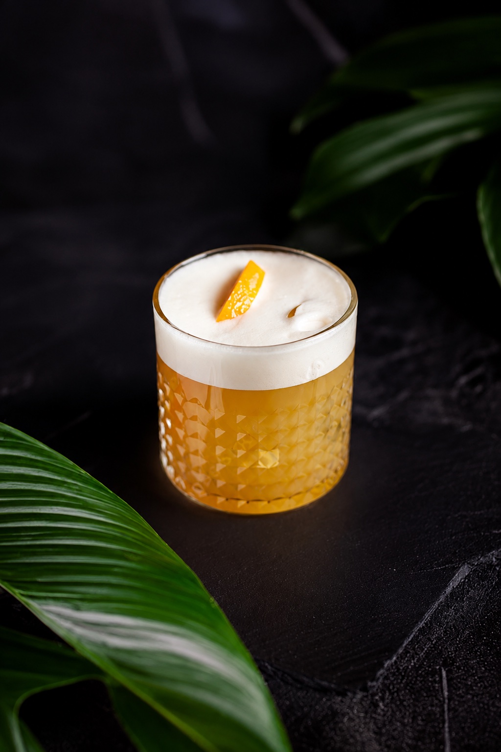 Whiskey Sour in a cut-crystal rocks glass with a silky foam crown and orange garnish